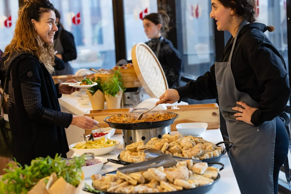 Catering staff serving guests from a freshly prepared event buffet